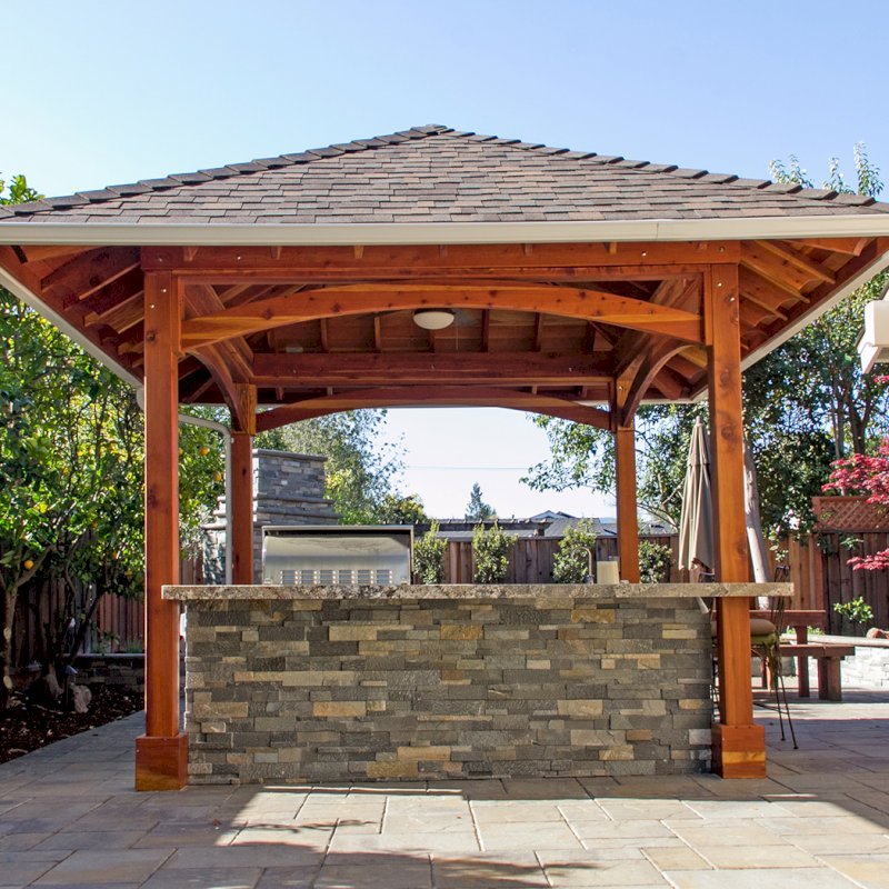 The Loreto Pavilion (Options: 14' x 14', California Redwood, Post Anchor Kit for Gale-Wind, 1 Electrical Wiring Trim Kit, 2ft Overhangs by Custom Request, Transparent Premium Sealant). Gutters added by Forever Redwood install team and can be added to any pavilion by request. Photo Courtesy of B. Hirschbeck of Los Altos, CA. The Loreto Pavilion (Options: 14' x 14', California Redwood, Post Anchor Kit for Gale-Wind, 1 Electrical Wiring Trim Kit, 2ft Overhangs by Custom Request, Transparent Premium Sealant). Gutters added by Forever Redwood install team and can be added to any pavilion by request. Photo Courtesy of B. Hirschbeck of Los Altos, CA.