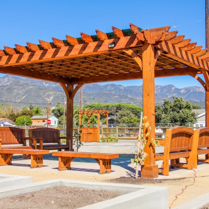 The Montvale Pergola (Options: 16' x 20', Mature Redwood, Post Anchoring for Concrete, No Ceiling Fan Base, No Curtain Rods, No Privacy Panels, 9.5' Post, Transparent Premium Sealant). Photo also shows some Luna Memorial Benches and Lighthouse Benches. Sunbrella shade fabric above the pergola was ordered from: www.patiolane.com as a custom item. Photo Courtesy of Carpinteria Park, 5775 Carpinteria Avenue Carpinteria, CA 93013. The Montvale Pergola (Options: 16' x 20', Mature Redwood, Post Anchoring for Concrete, No Ceiling Fan Base, No Curtain Rods, No Privacy Panels, 9.5' Post, Transparent Premium Sealant). Photo also shows some Luna Memorial Benches and Lighthouse Benches. Sunbrella shade fabric above the pergola was ordered from: www.patiolane.com as a custom item. Photo Courtesy of Carpinteria Park, 5775 Carpinteria Avenue Carpinteria, CA 93013.