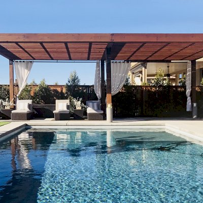 The Silverado Modern Pergola (Options: 30'-8" L, 16' W, California Redwood, No Electrical Wiring Trim, with 1 3/4" x 11 1/4" Roof Support Timbers and 7 1/4" x 7 1/4" Posts, Roof Rafter Spacing at 6", 6 Post Anchor Kit for High-Wind, No Privacy Panels, No Curtain Rods, 10' Post Height, Coffee-Stain Premium Sealant). Photo Courtesy of B. Aronson of Lincoln, CA.
