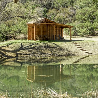Sunset Patio Pavilion Attached to a 12' x 12' Del Norte Pavilion (Options: 9' x 12', Douglas-fir, No Ceiling Fan Base, No Electrical Wiring Trim Kit, 2-Post Anchor Kit for High-Wind, with Custom Solid Wall, Transparent Premium Sealant). Photo Courtesy of J. Randall of Warner Springs, CA.