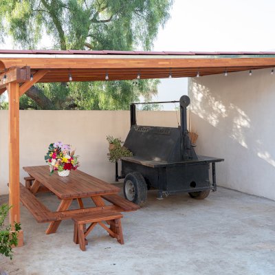 The Sunset Porch Pavilion (Options: 20' x 12', Posts and Roof Timbers are Mosaic Douglas-Fir, Parquet Roofing is Mosaic Redwood, 8ft H, No Electrical Wiring Trim, 2-Post Anchor Kit for Concrete, No Post Decorative Trim, No Ceiling Fan Base, No Curtain Rods, Transparent Premium Sealant). Internal Ceiling is Our New Parquet Roofing Finish in California Redwood. Photo Also Shows a Forever Picnic Table Set in Mosaic Mature Redwood.