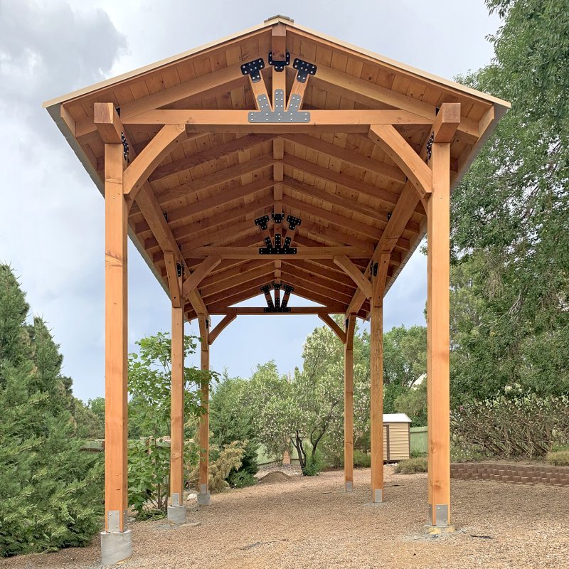 The Thick Timber Toledo Wood Pavilion (Options: 24' L x 14' W, Douglas-fir, 6-Post Anchor Kit High-Wind, No Electrical Wiring Trim, 8 x 8 Supports and Posts, 8 x 8 Rafters,12' H Posts, No Fan Base, Transparent Premium Sealant). This is an example of one way to design and build a pavilion when the ground is uneven. Photo Courtesy of J. Loessner of Albuquerque, New Mexico. The Thick Timber Toledo Wood Pavilion (Options: 24' L x 14' W, Douglas-fir, 6-Post Anchor Kit High-Wind, No Electrical Wiring Trim, 8 x 8 Supports and Posts, 8 x 8 Rafters,12' H Posts, No Fan Base, Transparent Premium Sealant). This is an example of one way to design and build a pavilion when the ground is uneven. Photo Courtesy of J. Loessner of Albuquerque, New Mexico.