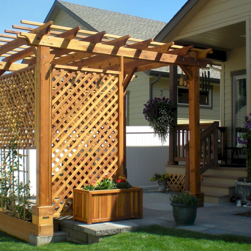 The Traditional Wooden Garden Pergola (Options: 10' L x 12' W, California Redwood, No Electrical Wiring Trim, Open Roof with Slats at 18", Rafters at 18", Widthwise Roof Support Timbers, 4-Post Anchor Kit for Stone, No Ceiling Fan Base, 3 Privacy Panels, No Curtain Rods, 9' Post Height, Transparent Premium Sealant). Photo Courtesy of Bill and Sandy Gibson of Coeur d'Alene, Idaho. The Traditional Wooden Garden Pergola (Options: 10' L x 12' W, California Redwood, No Electrical Wiring Trim, Open Roof with Slats at 18", Rafters at 18", Widthwise Roof Support Timbers, 4-Post Anchor Kit for Stone, No Ceiling Fan Base, 3 Privacy Panels, No Curtain Rods, 9' Post Height, Transparent Premium Sealant). Photo Courtesy of Bill and Sandy Gibson of Coeur d'Alene, Idaho.