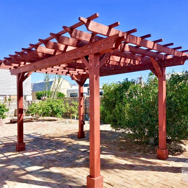 The Traditional Wooden Garden Pergola (Options: 16' L x 12' W, California Redwood, No Electrical Wiring Trim, Open Roof with Slats at 18", Rafters at 18", 4-Post Anchor Kit for Gale-Wind, No Ceiling Fan Base, No Privacy Panels, No Curtain Rods, 9' Post Height, Cherry Stain Premium Sealant). Photo Courtesy of N. Miller of Yuma, Arizona. The Traditional Wooden Garden Pergola (Options: 16' L x 12' W, California Redwood, No Electrical Wiring Trim, Open Roof with Slats at 18", Rafters at 18", 4-Post Anchor Kit for Gale-Wind, No Ceiling Fan Base, No Privacy Panels, No Curtain Rods, 9' Post Height, Cherry Stain Premium Sealant). Photo Courtesy of N. Miller of Yuma, Arizona.