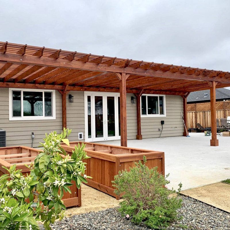 The Traditional Wooden Garden Pergola (Options: 42’ L x 16’-3 1/2” W, Old-Growth Redwood by Custom Request, No Electrical Wiring Trim, Open Roof with Slats at 6", Rafters at 18", 8-Post Anchor Kit for Concrete, No Ceiling Fan Base, No Privacy Panels, No Post Decorative Trims, No Curtain Rod, 10' Post Height, Transparent Premium Sealant). Photo Courtesy of D. Menzel of Santa Rosa, CA. The Traditional Wooden Garden Pergola (Options: 42’ L x 16’-3 1/2” W, Old-Growth Redwood by Custom Request, No Electrical Wiring Trim, Open Roof with Slats at 6", Rafters at 18", 8-Post Anchor Kit for Concrete, No Ceiling Fan Base, No Privacy Panels, No Post Decorative Trims, No Curtain Rod, 10' Post Height, Transparent Premium Sealant). Photo Courtesy of D. Menzel of Santa Rosa, CA.