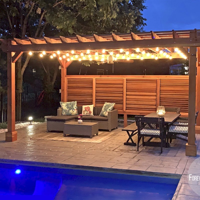 The Traditional Wooden Garden Pergola (Options: 18' L x 12' W, California Redwood, 1 Electrical Wiring Trim, Open Roof with Slats at 12", Rafters at 18", Lengthwise Roof Support Timbers, 4-Post Anchor Kit for Concrete, No Ceiling Fan Base, 1 Louver Privacy Panel Half Height Without Wall, 1 Curtain Rods, 9' Post Height, Transparent Premium Sealant). Photo Courtesy of Sasha Antskaitis of Louisville, Kentucky. The Traditional Wooden Garden Pergola (Options: 18' L x 12' W, California Redwood, 1 Electrical Wiring Trim, Open Roof with Slats at 12", Rafters at 18", Lengthwise Roof Support Timbers, 4-Post Anchor Kit for Concrete, No Ceiling Fan Base, 1 Louver Privacy Panel Half Height Without Wall, 1 Curtain Rods, 9' Post Height, Transparent Premium Sealant). Photo Courtesy of Sasha Antskaitis of Louisville, Kentucky.