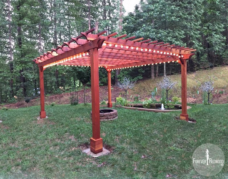 The Traditional Wooden Garden Pergola (Options: 18' L x 16' W, California Redwood, Electrical Wiring Trim for 1 Post, Open Roof with Slats at 12", Rafters at 18", Lengthwise Roof Support Timbers, 4-Post Anchor Kit for Gale-Wind, No Ceiling Fan Base, No Privacy Panels, No Curtain Rods, 9' Post Height, Transparent Premium Sealant). Photo Courtesy of A. Miller of Ellijay, Georgia. The Traditional Wooden Garden Pergola (Options: 18' L x 16' W, California Redwood, Electrical Wiring Trim for 1 Post, Open Roof with Slats at 12", Rafters at 18", Lengthwise Roof Support Timbers, 4-Post Anchor Kit for Gale-Wind, No Ceiling Fan Base, No Privacy Panels, No Curtain Rods, 9' Post Height, Transparent Premium Sealant). Photo Courtesy of A. Miller of Ellijay, Georgia.