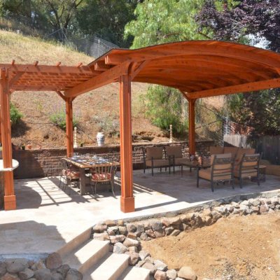 Garden Pergola Attached to a 18' x 18' Backyard Pavilion (Options: 14' L x 9' W, Mature Redwood, Electrical Wiring Trim for 1 Post, Open Roof with Slats at 18", Rafters at 18", Lengthwise Roof Support Timbers, 6 Post Anchor Kit for High-Wind, 2 Ceiling Fan Base, No Privacy Panels, No Curtain Rods, 10' Post Height, Transparent Premium Sealant). Photo Courtesy of J. Angwin of Morgan Hill, CA.