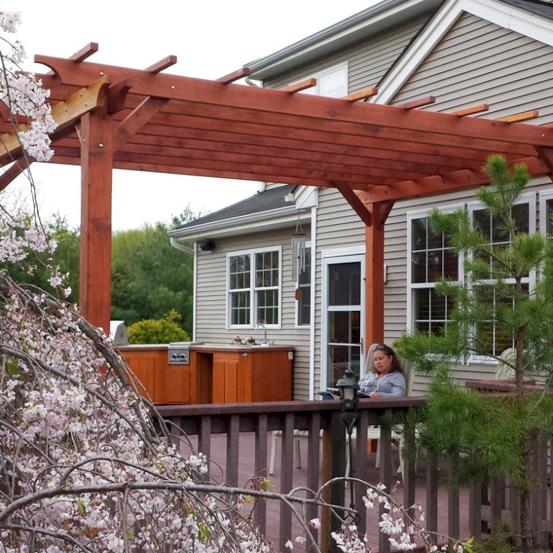 The Traditional Wooden Garden Pergola (Options: 15' L x 12' W, California Redwood, No Electrical Wiring Trim, Open Roof with Slats at 18", Rafters at 18", Widthwise Roof Support Timbers, 4- Post Anchor Kit for Wood, No ceiling Fan Base, No Privacy Panels, No Curtain Rods, 9' Post Height, Transparent Premium Sealant). Photo Courtesy of Ian Clarke of Allentown, NJ. The Traditional Wooden Garden Pergola (Options: 15' L x 12' W, California Redwood, No Electrical Wiring Trim, Open Roof with Slats at 18", Rafters at 18", Widthwise Roof Support Timbers, 4- Post Anchor Kit for Wood, No ceiling Fan Base, No Privacy Panels, No Curtain Rods, 9' Post Height, Transparent Premium Sealant). Photo Courtesy of Ian Clarke of Allentown, NJ.