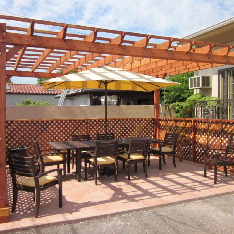 The Traditional Wooden Garden Pergola (Options: 18' x 14', California Redwood, No Electrical Wiring Trim, Open Roof with Slats at 18", Rafters at 18", Lengthwise Roof Support Timbers, 4-Post Anchor Kit for Stone, No Ceiling Fan Base, 3 Privacy Panels, No Curtain Rods, 9' Post Height, Transparent Premium Sealant). Photo Courtesy of Mike W. of Los Angeles, CA. The Traditional Wooden Garden Pergola (Options: 18' x 14', California Redwood, No Electrical Wiring Trim, Open Roof with Slats at 18", Rafters at 18", Lengthwise Roof Support Timbers, 4-Post Anchor Kit for Stone, No Ceiling Fan Base, 3 Privacy Panels, No Curtain Rods, 9' Post Height, Transparent Premium Sealant). Photo Courtesy of Mike W. of Los Angeles, CA.
