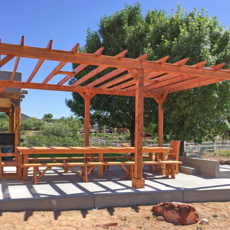 The Traditional Wooden Garden Pergola (Options: 22' L x 16' W, Douglas-fir, Electrical Wiring Trim for 1 Post, Open Roof with Rafters at 18", No Slats by Custom Request, Lengthwise Roof Support Timbers, 6-Post Anchor Kit for Concrete, with 2 Ceiling Fan Bases, No Privacy Panels, No Curtain Rods, 9.5' Post Height, Transparent Premium Sealant). Photo Also Shows a San Francisco Table Set. Photo Courtesy of Chris D. of Cornville AZ. The Traditional Wooden Garden Pergola (Options: 22' L x 16' W, Douglas-fir, Electrical Wiring Trim for 1 Post, Open Roof with Rafters at 18", No Slats by Custom Request, Lengthwise Roof Support Timbers, 6-Post Anchor Kit for Concrete, with 2 Ceiling Fan Bases, No Privacy Panels, No Curtain Rods, 9.5' Post Height, Transparent Premium Sealant). Photo Also Shows a San Francisco Table Set. Photo Courtesy of Chris D. of Cornville AZ.