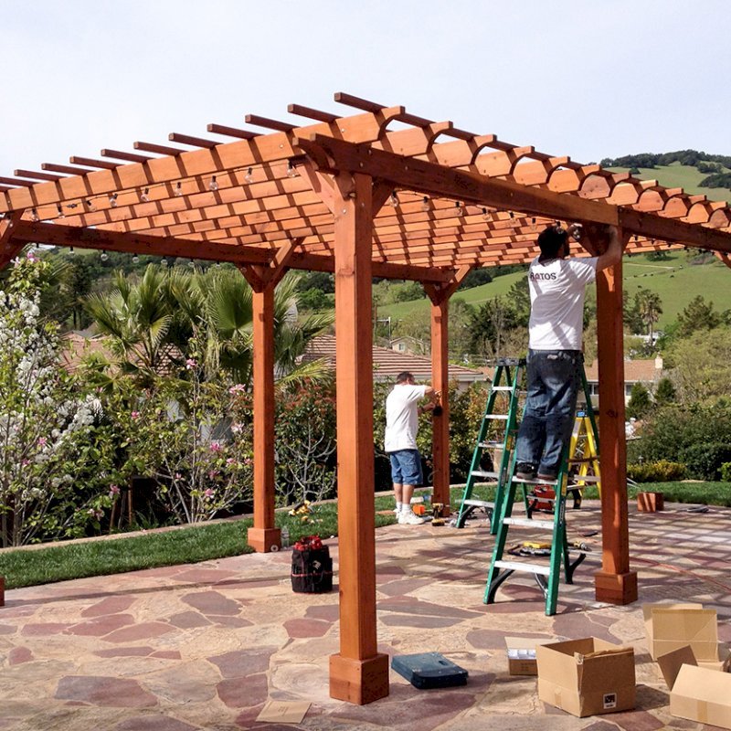 The Traditional Wooden Garden Pergola (Options: 22' L x 14' W, Mature Redwood, Electrical Wiring Trim for 2 Posts, Open Roof with Slats at 6", Rafters at 18", Widthwise Roof Support Timbers, 6-Post Anchor Kit for Concrete, No Ceiling Fan Base, No Privacy Panels, No Curtain Rods, 9.5' Post Height, Transparent Premium Sealant). Photo Courtesy of Roger Cassidy of Novato, CA. The Traditional Wooden Garden Pergola (Options: 22' L x 14' W, Mature Redwood, Electrical Wiring Trim for 2 Posts, Open Roof with Slats at 6", Rafters at 18", Widthwise Roof Support Timbers, 6-Post Anchor Kit for Concrete, No Ceiling Fan Base, No Privacy Panels, No Curtain Rods, 9.5' Post Height, Transparent Premium Sealant). Photo Courtesy of Roger Cassidy of Novato, CA.