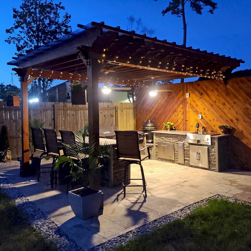 The Traditional Wooden Garden Pergola (Options: 18' L x 12' W, California Redwood, 1 Electrical Wiring Trim, Open Roof with Slats at 18", Rafters at 12" by Custom Request, with Rain Guard, 4-Post Anchor Kit for High-Wind, 2 Ceiling Fan Bases, No Privacy Panels, No Curtain Rods, 9.5' Posts, Transparent Premium Sealant). Rafters were designed with a slope for draining purpose. Photo Courtesy of M. McGourty of Virginia Beach, Virginia. The Traditional Wooden Garden Pergola (Options: 18' L x 12' W, California Redwood, 1 Electrical Wiring Trim, Open Roof with Slats at 18", Rafters at 12" by Custom Request, with Rain Guard, 4-Post Anchor Kit for High-Wind, 2 Ceiling Fan Bases, No Privacy Panels, No Curtain Rods, 9.5' Posts, Transparent Premium Sealant). Rafters were designed with a slope for draining purpose. Photo Courtesy of M. McGourty of Virginia Beach, Virginia.