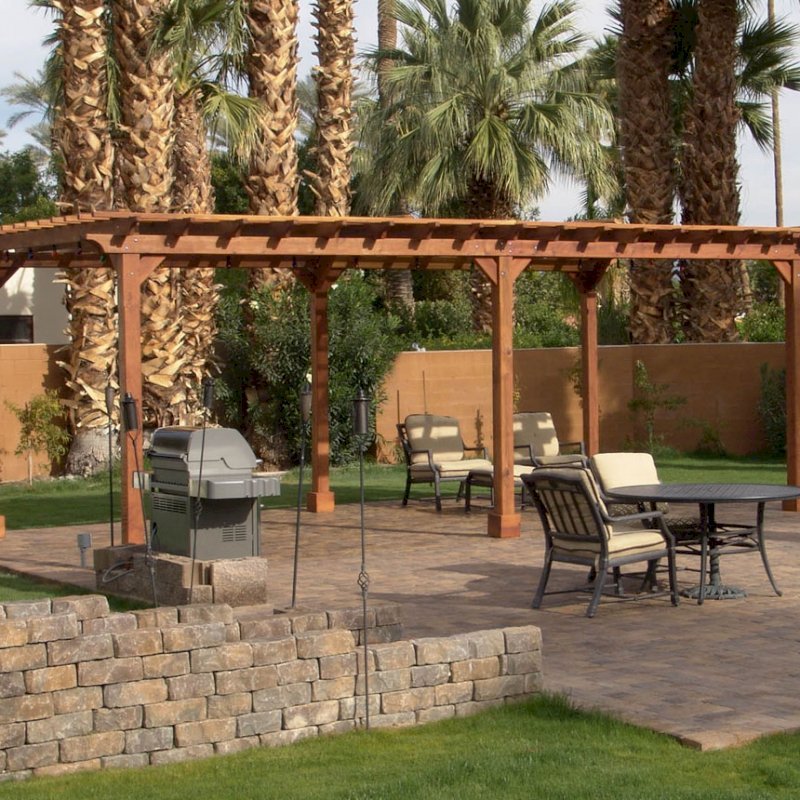 The Traditional Wooden Garden Pergola (Options: 26' L x 14' W, California Redwood, No Electrical Wiring Trim, Open Roof with Slats at 12", Rafters at 18", Lengthwise Roof Support Timbers, 6-Post Anchor Kit for Stone, No Ceiling Fan Base, No Privacy Panels, No Curtain Rods, 9' Post Height, Transparent Premium Sealant). Photo Courtesy of Val Kay of Indian Wells, CA. The Traditional Wooden Garden Pergola (Options: 26' L x 14' W, California Redwood, No Electrical Wiring Trim, Open Roof with Slats at 12", Rafters at 18", Lengthwise Roof Support Timbers, 6-Post Anchor Kit for Stone, No Ceiling Fan Base, No Privacy Panels, No Curtain Rods, 9' Post Height, Transparent Premium Sealant). Photo Courtesy of Val Kay of Indian Wells, CA.