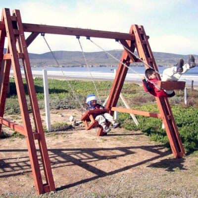 Rory's Grande Playground Swing - Mature Redwood with Toddler/Small Kid's Swing Seat - left (Options: Mature Redwood, Chain & Eye Bolts, Transparent Premium Sealant) and Toddler Swing Seats - right (Options: Mature Redwood, Transparent Premium Sealant).