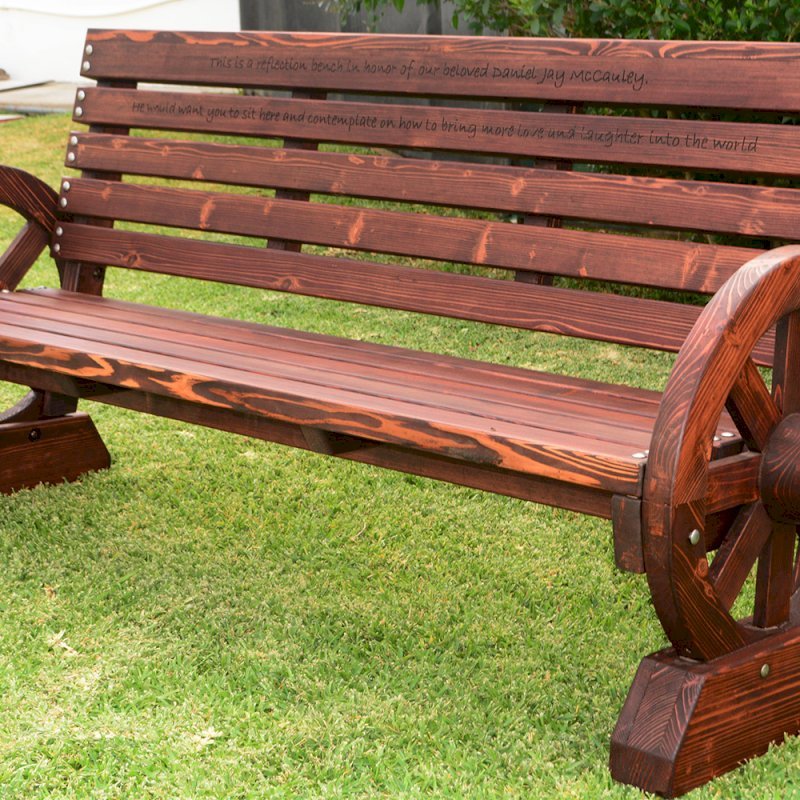 Wagon Wheel Bench (Options. 6 ft, Mature Redwood (20-yr Warranty) , No Cushion, Custom Engraving - 51-100 chars, Cherry Stain Premium Sealant). Wagon Wheel Bench (Options. 6 ft, Mature Redwood (20-yr Warranty) , No Cushion, Custom Engraving - 51-100 chars, Cherry Stain Premium Sealant).