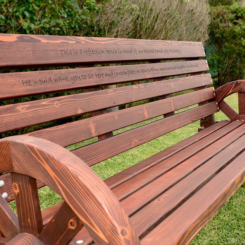 Wagon Wheel Wooden Bench (Options. 6 ft, Mature Redwood (20-yr Warranty) , No Cushion, Custom Engraving - 51-100 chars, Cherry Stain Premium Sealant). Wagon Wheel Wooden Bench (Options. 6 ft, Mature Redwood (20-yr Warranty) , No Cushion, Custom Engraving - 51-100 chars, Cherry Stain Premium Sealant).