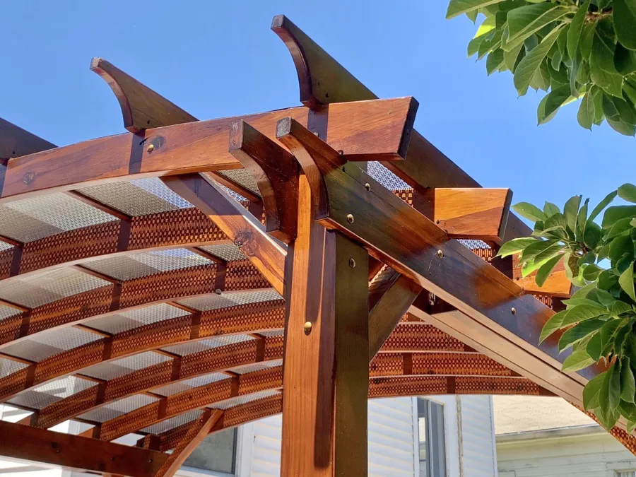 Arched Open Sky Pergolas (Options: 12' L x 14' Arc W, California Redwood, 1 Electrical Wiring Trim, 4-Post Anchor Kit for Concrete, No Ceiling Fan Base, No Privacy Panels, No Curtain Rods, 9.5' Post Height, Transparent Premium Sealant). Custom decorative steel shading added by customer. Photo was taken one year after installation. Photo Courtesy of K. Cates of Oajland, California.