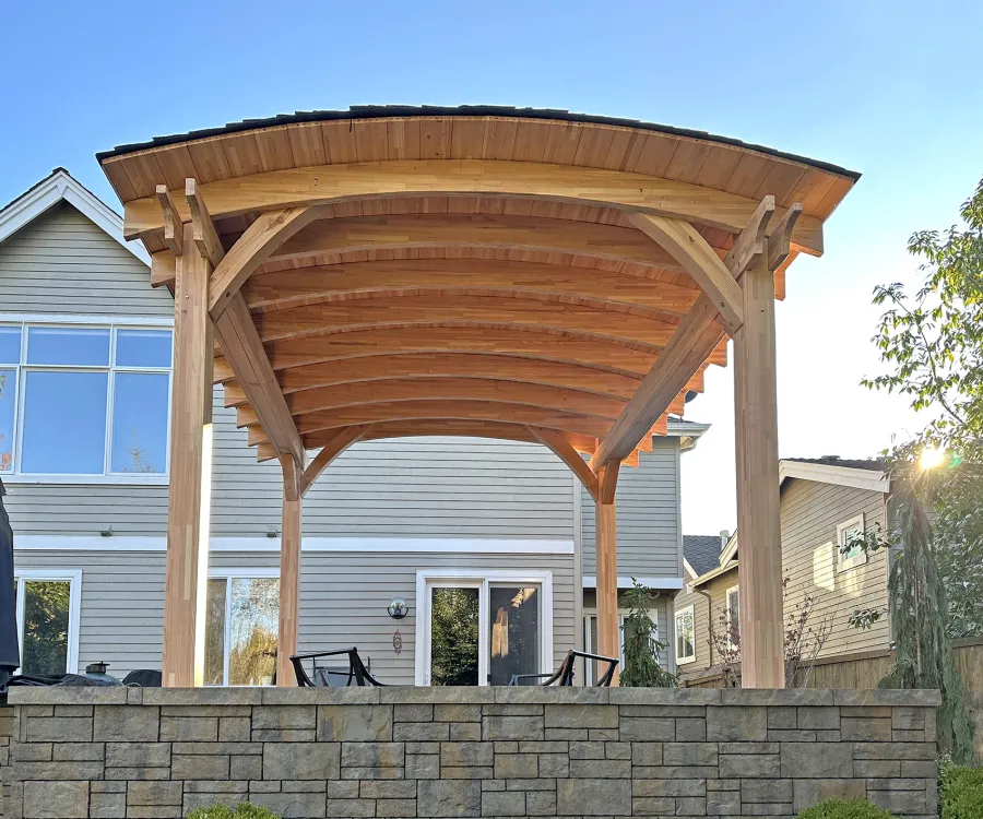  Arched Thick Timber Pavilion (Options: 14' L x 14' Arc W, Mosaic Douglas-fir, 2 Electrical Wiring Trims, 4-Post Anchor Kit for High-Wind, 1 Ceiling Fan Base, 11' H Posts, No Privacy Panel, No Curtain Rods, 12 ft H, No Decorative Trims on Posts, Unfinished). Photo Courtesy of K. Bachman-Ellis of Bellevue, WA.