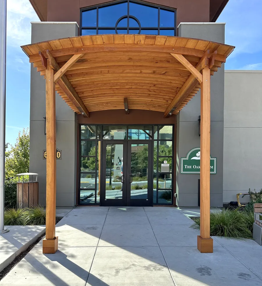 Custom  Arched Thick Timber Pavilion (Options: 10' L x 12' Arc W, Douglas-fir, 2-Post Anchor Kit for Concrete, No Ceiling Fan Base, 11'-5" H Posts, No Privacy Panel, No Curtain Rods, No Decorative Trims on Posts, Transparent Premium Sealant). Pavilion attached as an extension of an existing 5' L roof. Photo Courtesy of R. Cole of Fairfield, CA.