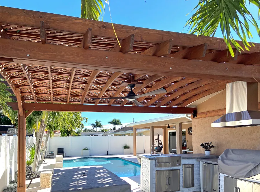 Attached Arched Pergola Kits (Options: 15' L x 20' W, Douglas-fir, Vertical Post Decorative Trims, 1 Electrical Wiring Trim, Rafters at 18" and Slats at 18", Widthwise Roof Support Timbers, 2-Post Anchor Kit for Concrete, 1 Ceiling Fan Base, No Privacy Panels, No Curtain Rods, 9' Post Height, Coffee-Stain Premium Sealant). Photo Courtesy of N. Lizazo of Sunrise, FL.