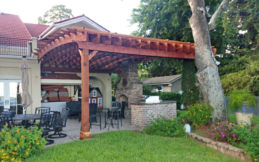 Custom Attached Arched Pergola Kits (Options: 22' L x 26' W, California Redwood, No Electrical Wiring Trim, Rafters at 18" and Slats at 18", 3-Post Anchor Kit for High-Wind, with Transparent Rain Guard, Ceiling Fan Base, No Privacy Panels, No Curtain Rods, 10' Post Height, Transparent Premium Sealant, Attached to Wall by Support Side, Arches are 2x12's by Custom Request). Photo Courtesy of M. Yocco of Hilton Head, South Carolina.