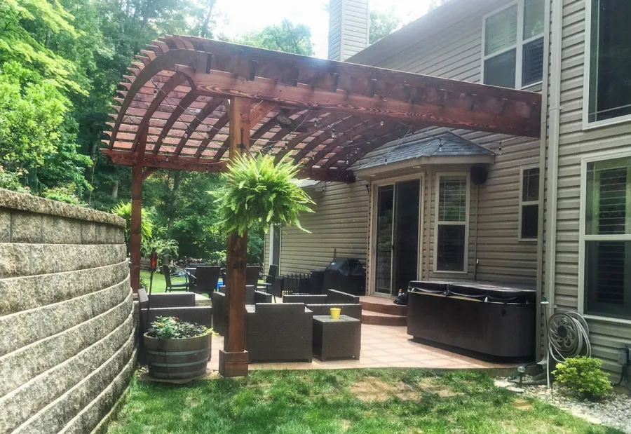 Attached Arched Pergola Kits (Options: 20' L x 26' W, Douglas-fir, No Electrical Wiring Trim, Rafters at 18" and Slats at 18", Widthwise Roof Support Timbers, 2-Post Anchor Kit for Concrete, Ceiling Fan Base, No Privacy Panels, No Curtain Rods, 11' Post Height, Coffee-Stain Premium Sealant). Photo Courtesy of Susanne Stephens of Eureka, Missouri.