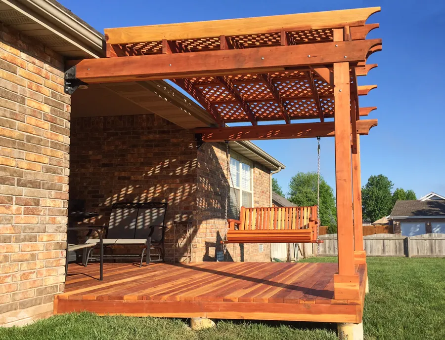 Attached Arched Pergola Kits (Options: 10' x 10', California Redwood, No Electrical Wiring Trim, with Lattice Panels, 2-Post Anchor Kit for Concrete, No Ceiling Fan Base, No Privacy Options, No Curtain Rods, 9ft H, Transparent Premium Sealant) with Deck and Bench Swing by Custom Request. Photo Courtesy of Telory of A. of Springfield, MO.. 