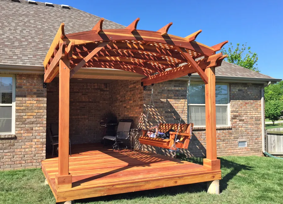 Attached Arched Pergola Kits (Options: 10' x 10', California Redwood, No Electrical Wiring Trim, with Lattice Panels, 2-Post Anchor Kit for Concrete, No Ceiling Fan Base, No Privacy Options, No Curtain Rods, 9ft H, Transparent Premium Sealant) with Deck and Bench Swing by Custom Request. Photo Courtesy of Telory of A. of Springfield, MO.. 