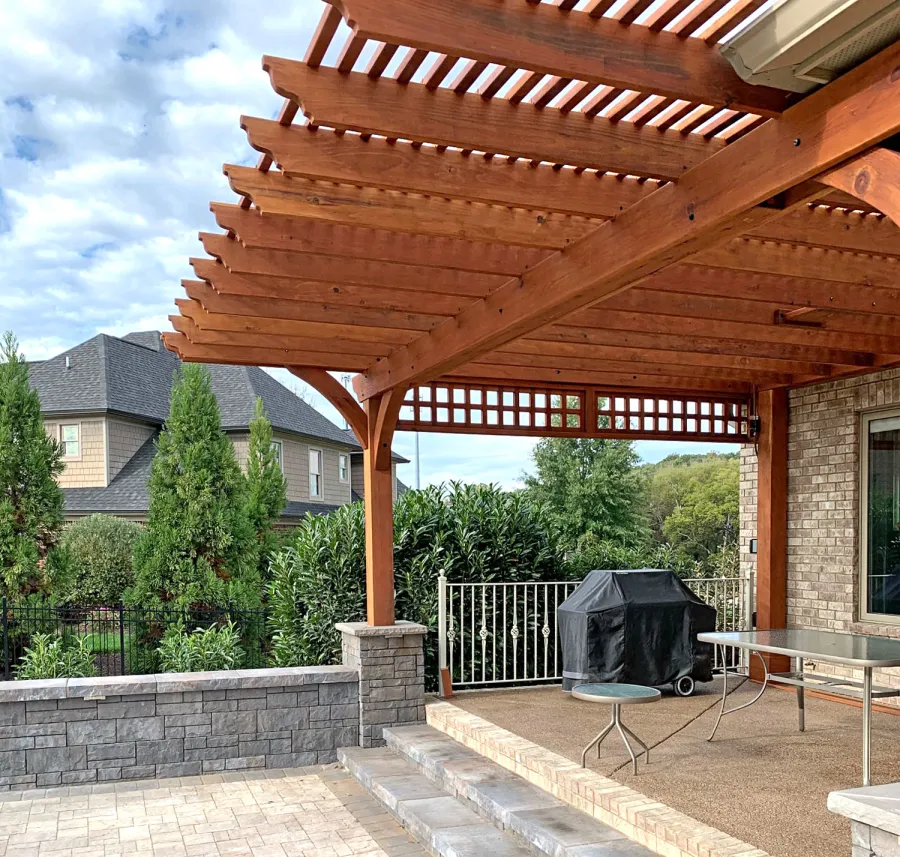 Custom Attached Garden Pergola (Options: 21' x 18', Mature Redwood, 1 Custom Lattice Privacy Panel, 1 Ceiling Fan Base, Transparent Premium Sealant). This customized attached pergola was built to fit around a low roof with an extended overhang and posts up against the house to meet the customer's vision perfectly. Photo Courtesy of B. McAdams of Farragut, Tennessee.