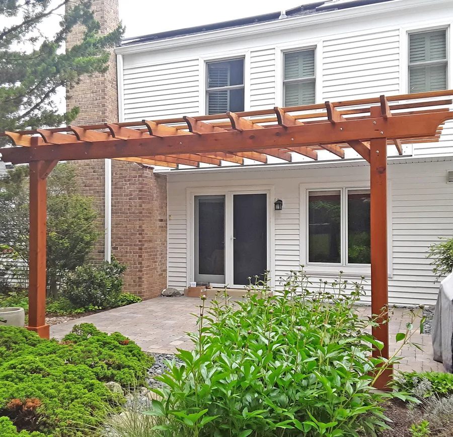 Attached Garden Perglola (Options: 18' x 15', California Redwood, Open Roof with Slats at 18", Rafters at 18", Attached to the Wall by Support Side, 2-Post Anchor Kit for Concrete, 1 Ceiling Fan Base, Transparent Premium Sealant). Custom framed 2' x 2' Polycarbonate Rain Guard Centered Atop Ceiling Fan Base to Protect Fan From Moisture. Photo Courtesy of M. Holland of Potomac, Maryland.