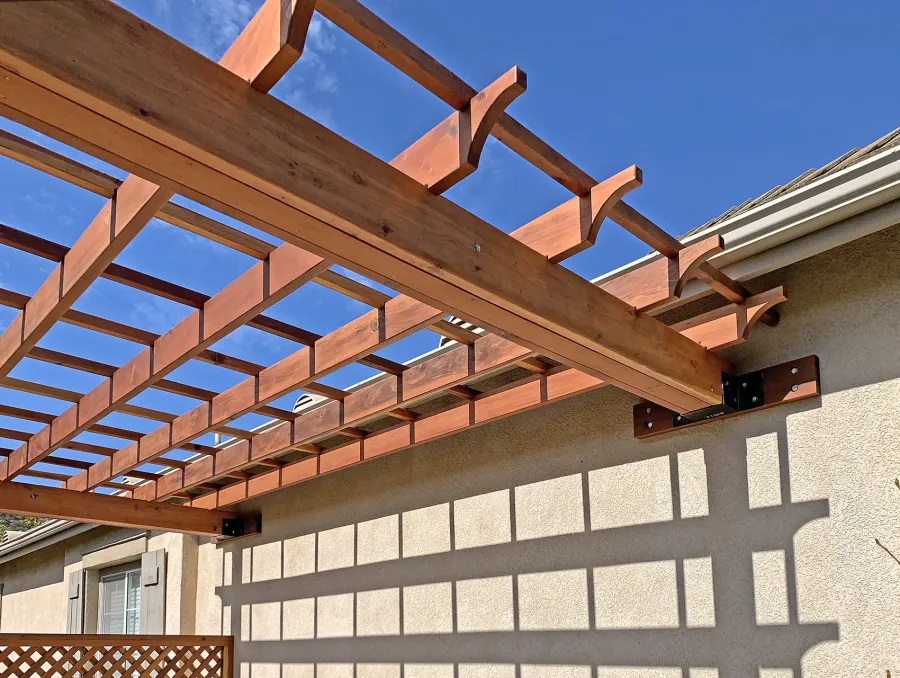 Attached Garden Perglola (Options: 12'-6" x 16', California Redwood, Open Roof with Slats at 18", Rafters at 18", Attached to the Wall by Rafter Side, 2-Post Anchor Kit for Concrete, 1 Lattice Privacy Panel, No Ceiling Fan Base, Transparent Premium Sealant). Photo Courtesy of S. Abbasi of Newbury Park, CA.