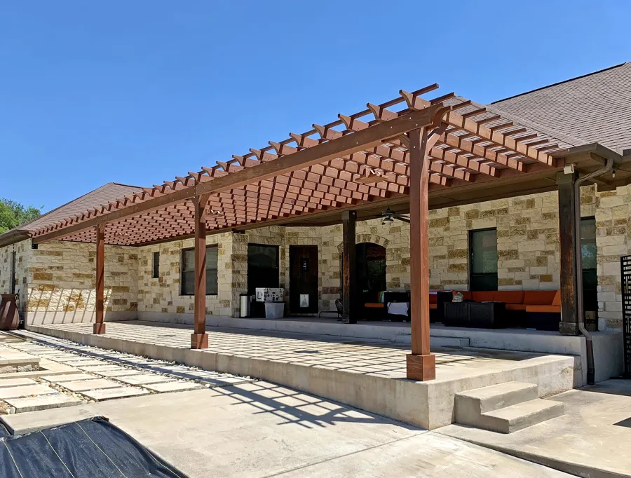 Custom Attached Garden Pergola (Options: 53' x 12', California Redwood, Open Roof with Slats at 12", Rafters at 18", 3-Post Anchor Kit for Concrete, 3 Ceiling Fan Bases, Coffee-Stain Premium Sealant). Ledger Board Attached to Wood House Fascia on 53' Side, and Steel Plate Used to Attach Dual Supports to Masonry House Wall. Photo Courtesy of S. Slawson of Buda, Texas.