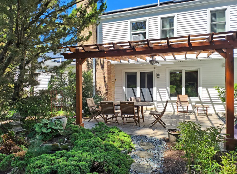 Attached Garden Pergola (Options: 18' x 15', California Redwood, Open Roof with Slats at 18", Rafters at 18", 2-Post Anchor Kit for Concrete, 1 Ceiling Fan Base, Transparent Premium Sealant). Custom framed 2' x 2' Polycarbonate Rain Guard centered atop ceiling fan base to protect fan from moisture. Photo Taken 6 Months After Installation. Photo Courtesy of M. Holland of Potomac, Maryland.
