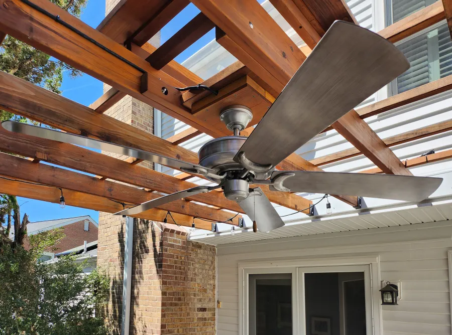 Attached Garden Pergola (Options: 18' x 15', California Redwood, Open Roof with Slats at 18", Rafters at 18", 2-Post Anchor Kit for Concrete, 1 Ceiling Fan Base, Transparent Premium Sealant). Custom framed 2' x 2' Polycarbonate Rain Guard centered atop ceiling fan base to protect fan from moisture. Photo Taken 6 Months After Installation. Photo Courtesy of M. Holland of Potomac, Maryland.