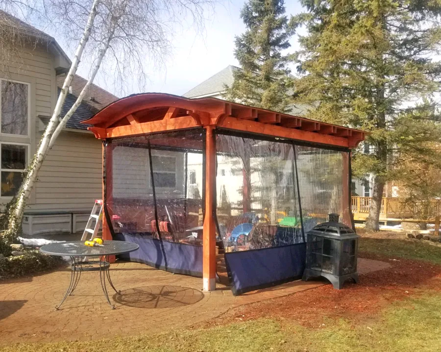 Custom Backyard Pavilion Kit with Extra Supports and Braces on Arches Side (Options: 16' L x 12' Arc W, Douglas-fir, 1 Post Electrical Wiring Trim, 4-Post Anchor Kit for High-Wind, 1 TV Mount Base by Custom Request, No Privacy Panels, No Curtain Rods, 9 ft Post Height, Cherry-Stain Premium Sealant). Photo Courtesy of E. Chen of Ann Arbor, Michigan.