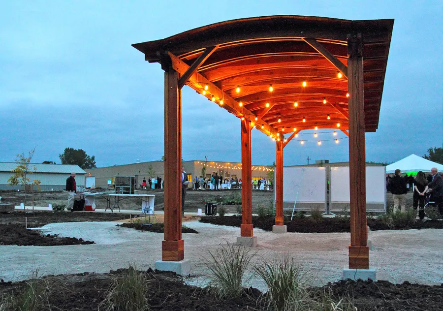 Backyard Pavilion Kits (Options: 30' L x 10' Arc W, California Redwood, No Electrical Wiring Trim, 4-Post Anchor Kit for High-Wind, No Ceiling Fan Base, No Privacy Panels, No Curtain Rods, 9 ft Post Height, Transparent Premium Sealant). Photo Courtesy of Sara Wilson of Ankeny, Iowa.