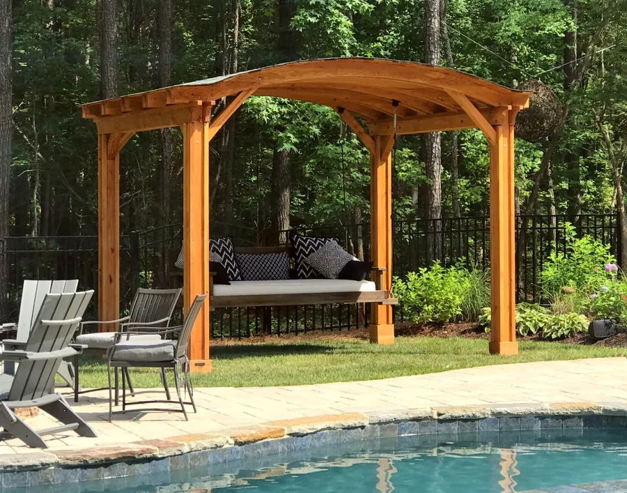 Backyard Pavilion Kits (Options: 12' L x 10' Arc W, Douglas-fir, No Electrical Wiring Trim, 4-Post Anchor Kit for High-Wind, No Ceiling Fan Base, No Privacy Panels, No Curtain Rods, 9 ft Post Height, Transparent Premium Sealant). Swing added by customer. Photo Courtesy of E. Schechtman of Wake Forest, NC.