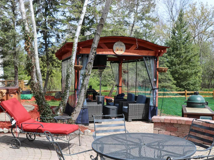 Custom Backyard Pavilion Kit with Extra Supports and Braces on Arches Side (Options: 16' L x 12' Arc W, Douglas-fir, 1 Post Electrical Wiring Trim, 4-Post Anchor Kit for High-Wind, 1 TV Mount Base by Custom Request, No Privacy Panels, No Curtain Rods, 9 ft Post Height, Cherry-Stain Premium Sealant). Photo Courtesy of E. Chen of Ann Arbor, Michigan.