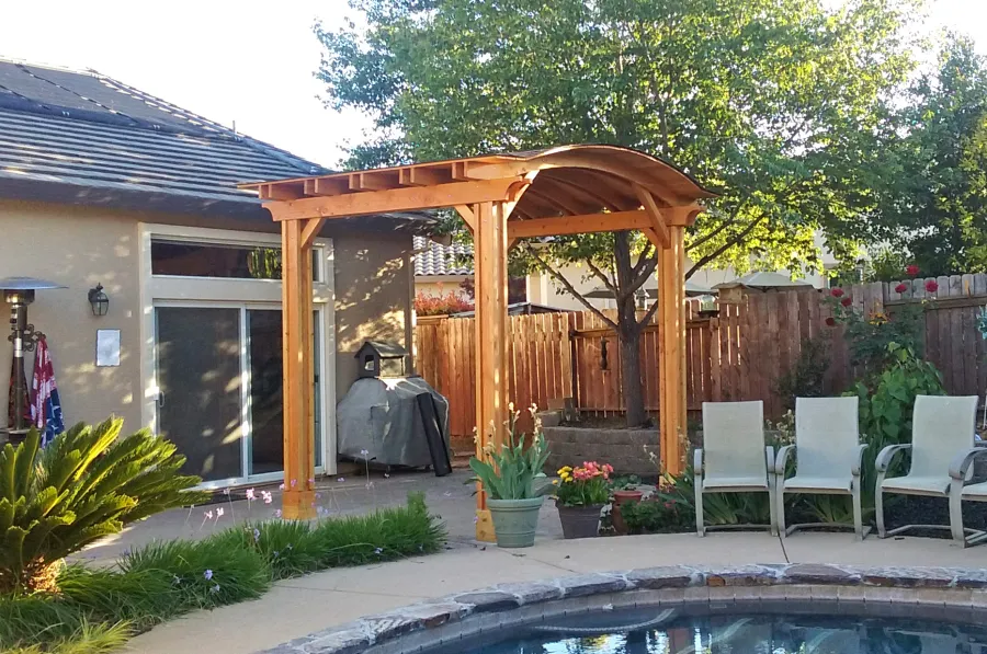 Backyard Pavilion Kits (Options: 12' L x 10' Arc W, Douglas-fir, 1 Post Electrical Wiring Trim, 4-Post Anchor Kit for Concrete, Add Ceiling Fan Base, No Privacy Panels, No Curtain Rods, 9 ft Post Height, Transparent Premium Sealant). Photo Courtesy of R. Short of Roseville, CA.