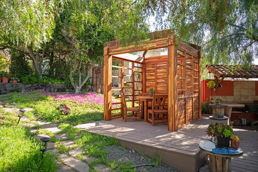 Catalina Island Pergola (Options: 8' x 8', Mosaic Redwood, 8' Post Height, Transparent Premium Sealant). Photo Also Shows a Round Patio Table with Segovia Chairs.