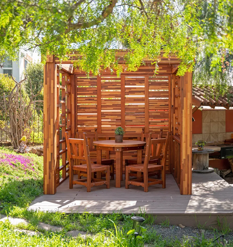 Catalina Island Pergola (Options: 8' x 8', Mosaic Redwood, 8' Post Height, Transparent Premium Sealant). Photo Also Shows a Round Patio Table with Segovia Chairs.