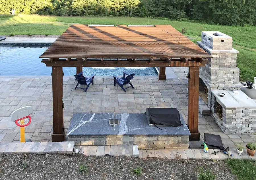 Custom Garden Pergola (Options: 16' L x 16' W, California Redwood, 4-Post Anchor Kit for Concrete, Cherry Stain Premium Sealant). Plumbing was built into the timbers to create a waterfall. Photo Courtesy of D. Hogan of Charlottesville, Virginia.