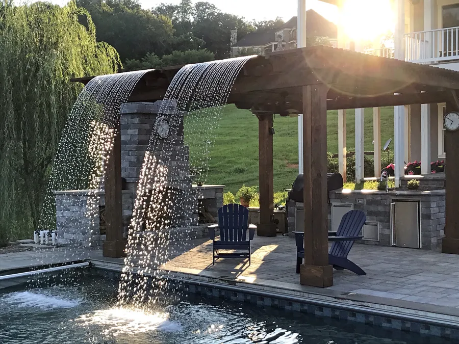 Custom Garden Pergola (Options: 16' L x 16' W, California Redwood, 4-Post Anchor Kit for Concrete, Cherry Stain Premium Sealant). Plumbing was built into the timbers to create a waterfall. Photo Courtesy of D. Hogan of Charlottesville, Virginia.