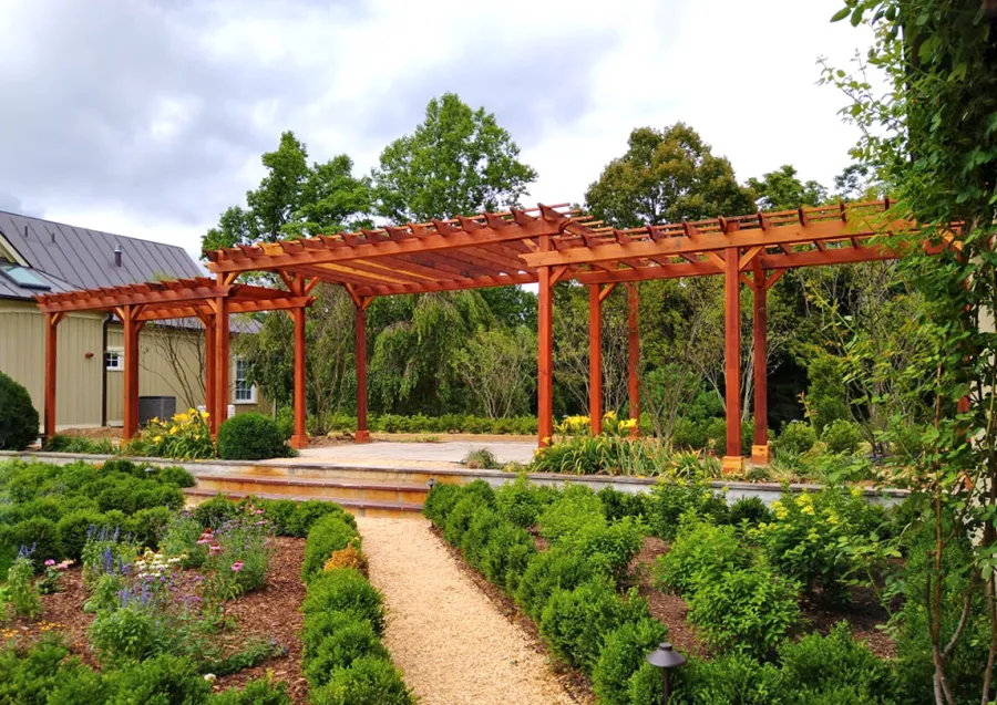 Custom Wooden Pergola (Options: 56' L [20' W in Central Section and 8' W on Sides], Mature Redwood, No Electrical Wiring Trim, 14-Post Anchor Kit for Concrete, No Ceiling Fan Base, No Privacy Panels, No Curtain Rods, Transparent Premium Sealant). Photo Courtesy of J. Kelly of Crozet, Virginia.