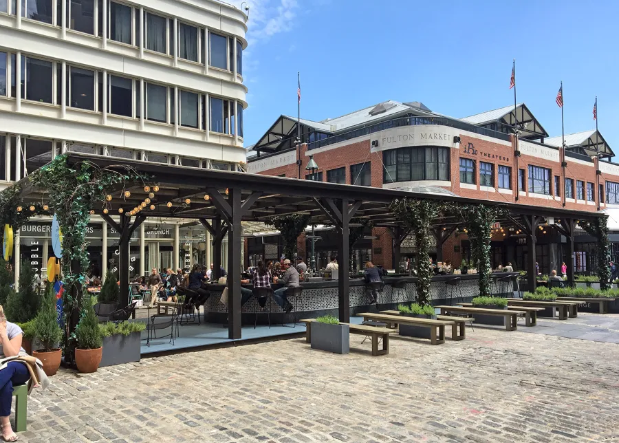 Custom Wooden Pergola (Options: 82' L x 16' W, Douglas-fir, Open Roof with Rafters at 18", with Transparent Rain Guard, 12-Post Anchor Kit, No Ceiling Fan Base, 12' Post Height, Custom Black Paint). This pergola is part of the giant popup beer hall at the Southside Seaport in downtown Manhattan from May to Oct 2017: https://www.timeout.com/newyork/blog/a-giant-pop-up-beer-hall-is-opening-at-south-street-seaport-this-summer-032417