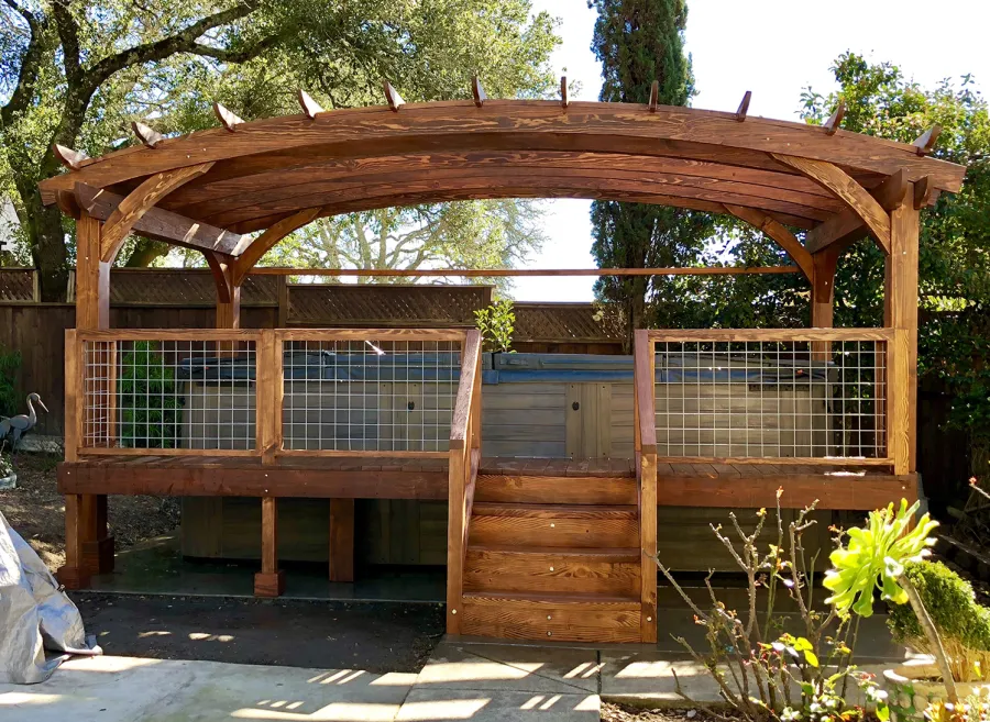 Custom Arched Pergola Kits (Options: 12' L x 22' Arc W, Douglas-fir, Unattached, Electrical Wiring Trim Kit for 1 Post, Arched Roof with Lattice Panels and Acrylic Sheets Centered, 4-Post Anchor Kit for Stone, with 8 x 8 Posts by Custom Request, No Ceiling Fan Base, No Privacy Panels, 1 Curtain Rod, 9' Post Height, Coffee-Stain Premium Sealant) with Custom Deck and Stairs by Custom Request. Photo Courtesy of Steve & Heidi Jones of Windsor, CA.