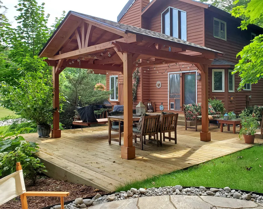 Del Norte Outdoor Kitchen Pavilion (Options: 14' L x 12' W, Douglas-fir, No Privacy Panel, Post Anchor Kit for High Wind, 10' H Posts, No Ceiling Fan Base, No Curtain Rod, Transparent Premium Sealant) with a 6' Jhoola Day Bed Swing. Photo Courtesy of M. Jossens of Traverse City, MI.