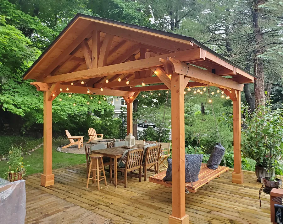 Del Norte Outdoor Kitchen Pavilion (Options: 14' L x 12' W, Douglas-fir, No Privacy Panel, Post Anchor Kit for High Wind, 10' H Posts, No Ceiling Fan Base, No Curtain Rod, Transparent Premium Sealant) with a 6' Jhoola Day Bed Swing. Photo Courtesy of M. Jossens of Traverse City, MI.