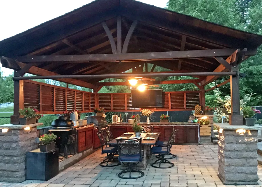Del Norte Outdoor Kitchen Pavilion (Options: 20' L x 18' W, Mature Redwood, 4-Post Kit for High-Wind, 2 Ceiling Fan Bases, 2 Electrical Wiring Trim Kits, 2 Sets of Louvers on 2 Sides, No Post Decorative Trims, 9' H Posts Wrapped in Stone After Installation, Coffee-Stain Premium Sealant). Photo Courtesy of Shawn and Marilyn Murray of Walden, New York.